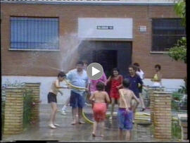 Vecino mojando a un grupo de niños con una manguera. 1991. Sevilla (España).